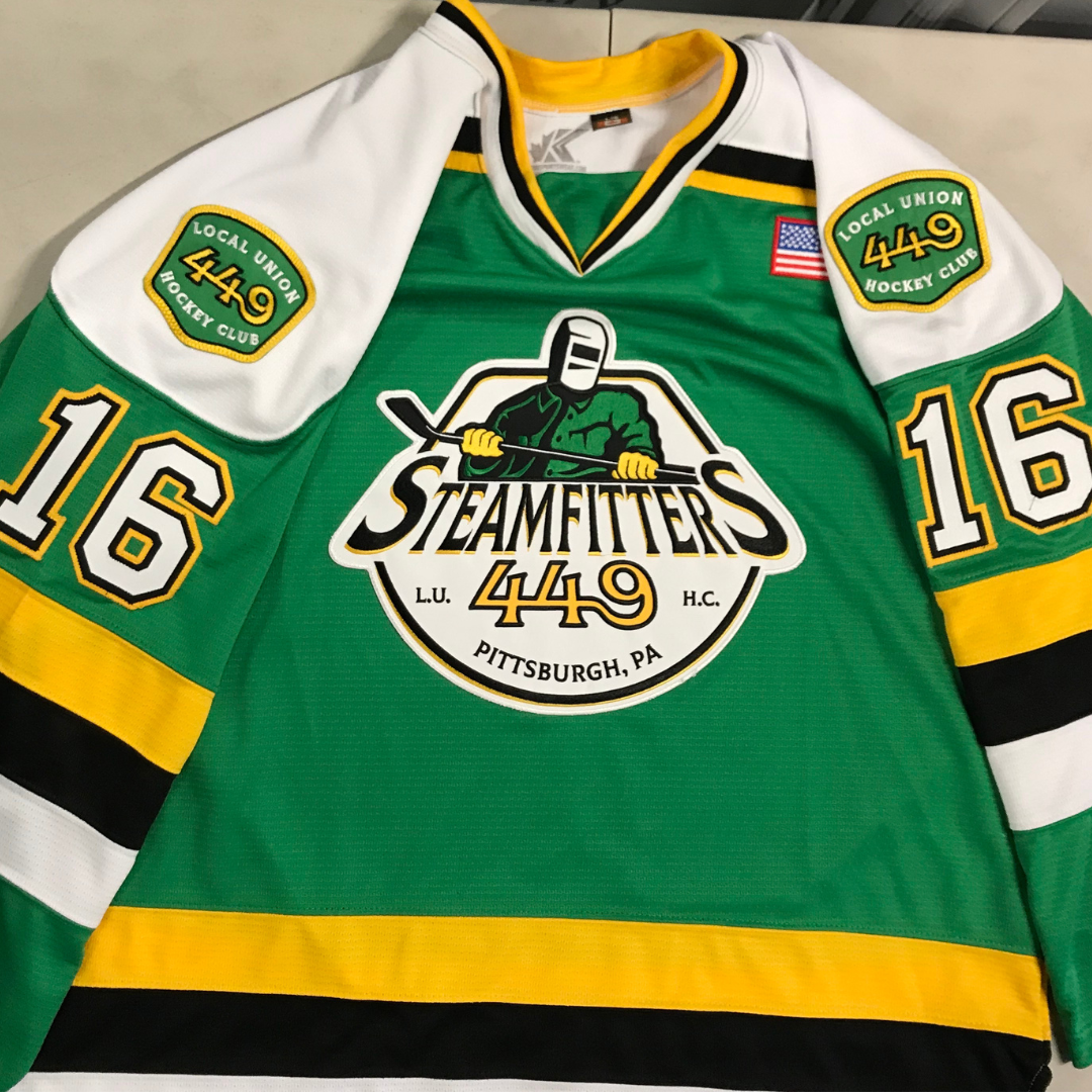 Custom pro-style hockey jersey—green, yellow, and white—with an embroidered pro twill logo on the front and shoulders. 